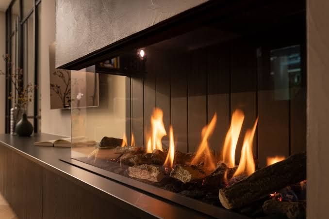A built-in fireplace with a wide glass front