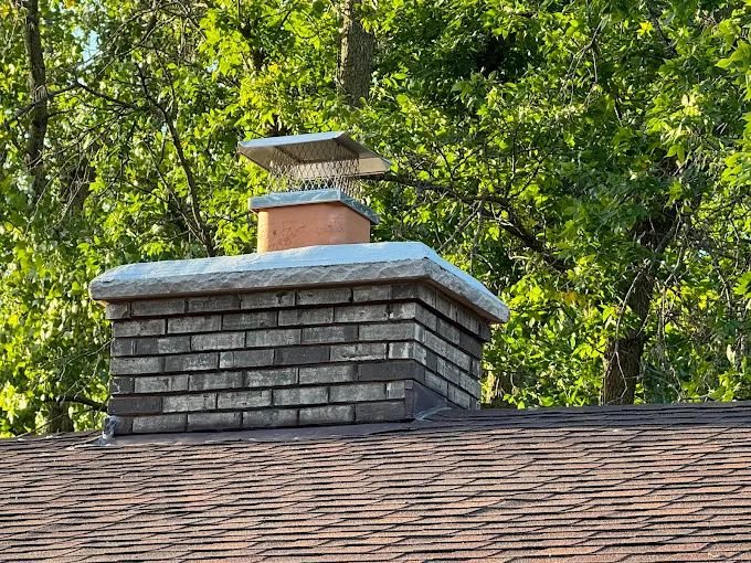 A chimney cap surrounded by trees
