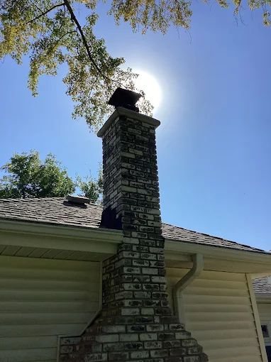 A tall brick chimney standing against a clear sky