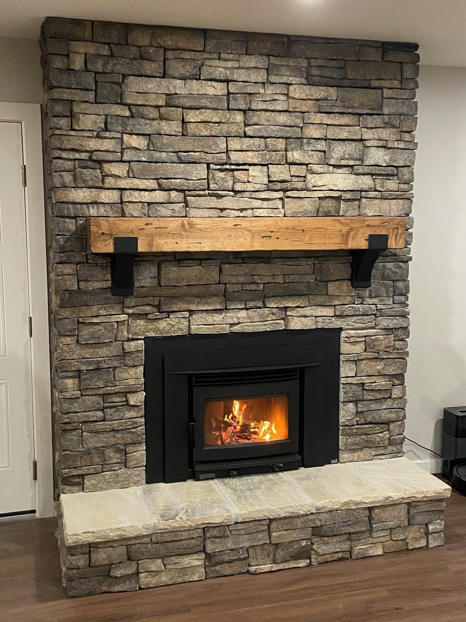 Wood-burning insert set into a stone fireplace